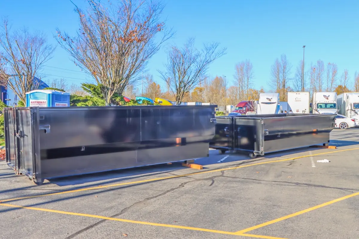 Professional dumpster rental service with roll-off container on residential driveway in Boylston